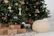 Regali di Natale impacchettati sotto un albero di Natale naturale e decorato.