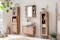 Meuble de salle de bain de style bohème en bois d'acacia avec des motifs de couleur crème, entourés de plantes vertes, de lanternes, de nombreux paniers de rangement et d'un tapis en jute.