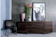 Schwarzer Stuhl und dunkles Sideboard vor grau und blau gestrichener Wand