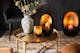 Vue d'oiseau d'une table festive avec de la vaisselle dorée, des bougies scintillantes, un photophore et des accessoires marocains.