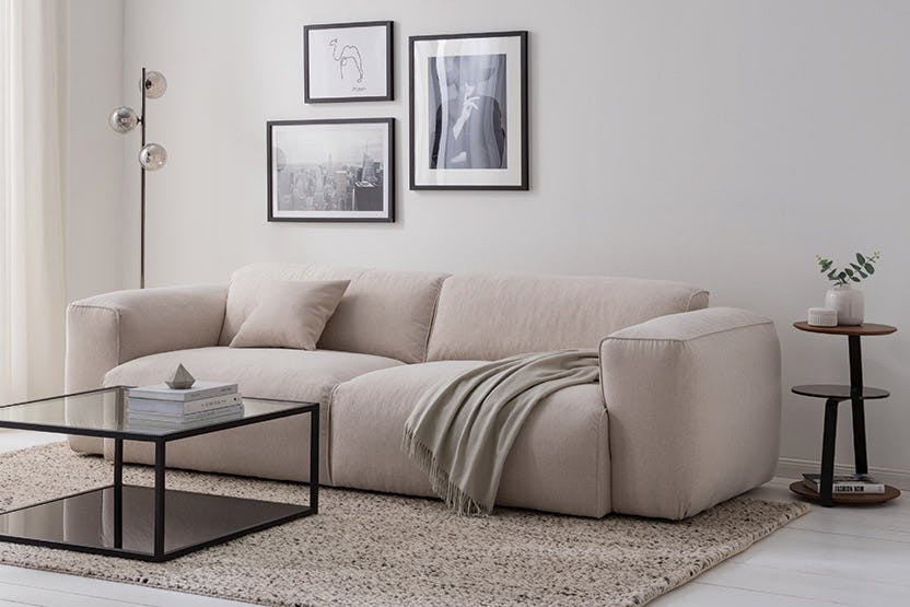 Beigefarbenes Einzelsofa mit schwarzem Couchtisch