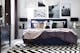 Elegantes Schlafzimmer im schwarz-weißen Setting mit silbernen Highlights an Lampe und Nachttisch