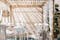 Terrazzo in stile mediterraneo con sedie, tavoli e panche in legno verniciato bianco, lampada a sospensione in materiali naturali e tessili color carta da zucchero