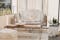 Terrazzo con divano a due posti bianco, tavolino in legno e pouf beige in stile boho su tappeto a pelo lungo bianco