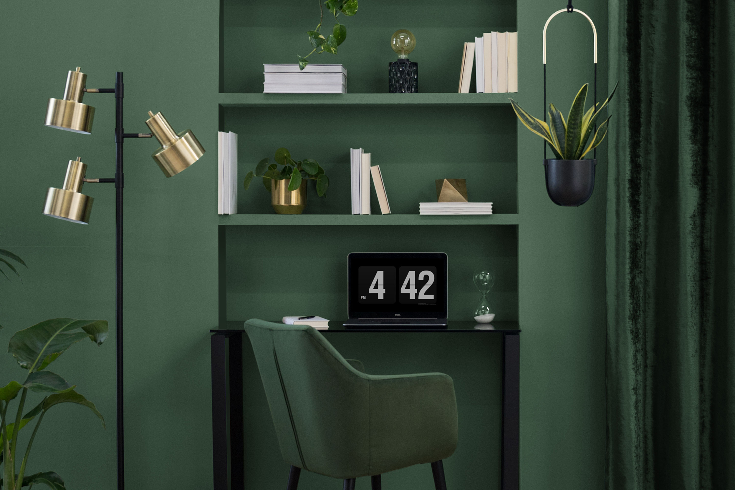 Schlafzimmer mit integrierter Arbeitsecke mit grünen Möbeln sowie goldenen und schwarzen Elementen im Retro-Stil.