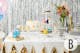 Feesttafel met gouden confetti, pastelballonnen, taart, cadeautjes, een etagère, champagne en meer van BUTLERS.