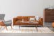 Gemütliche Wohnzimmer mit Leder Sofa, Sessel und holz kommode in skandi Stil - home24