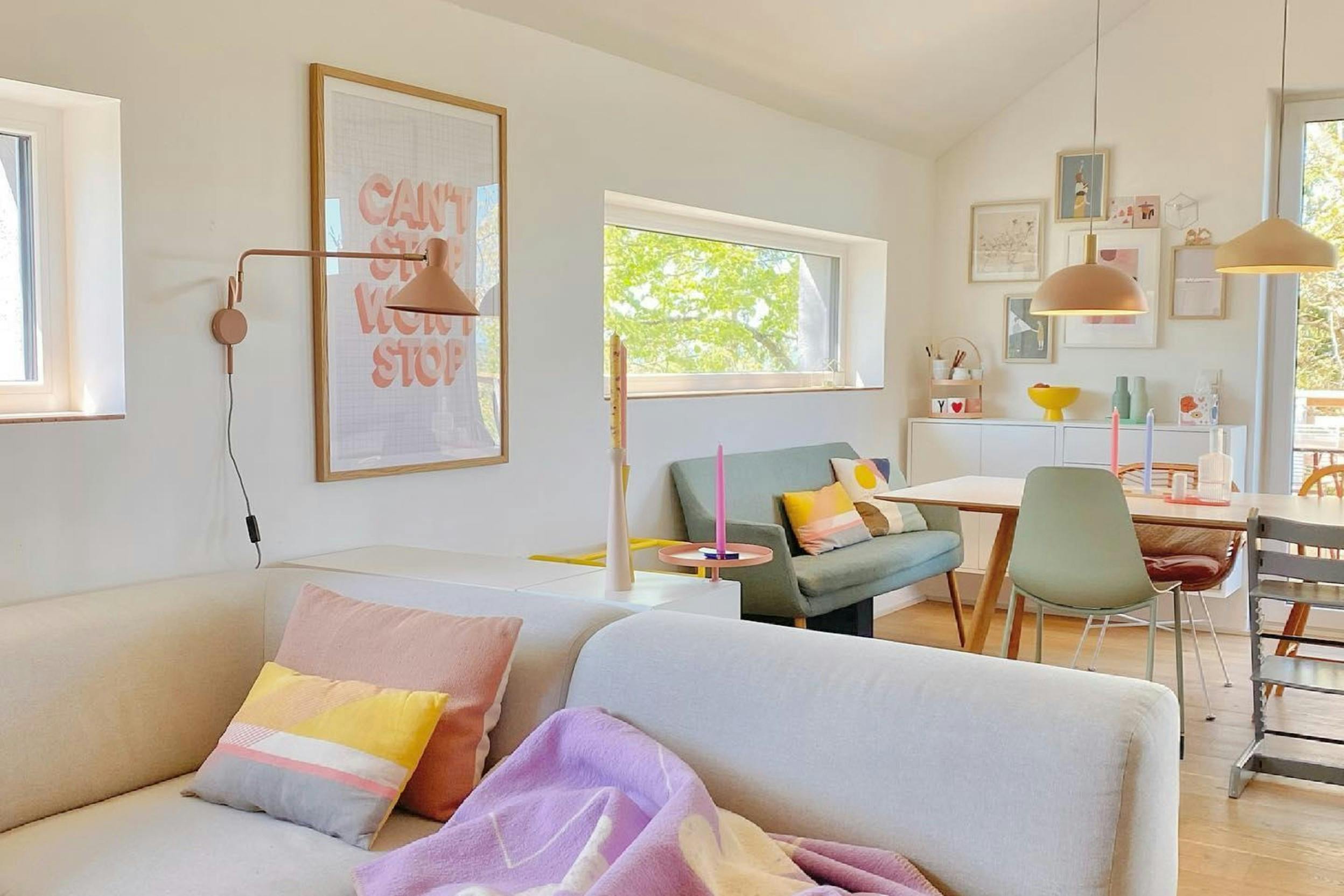 Farbenfrohes Wohnzimmer mit Essbereich, der durch ein Ecksofa abgetrennt ist.