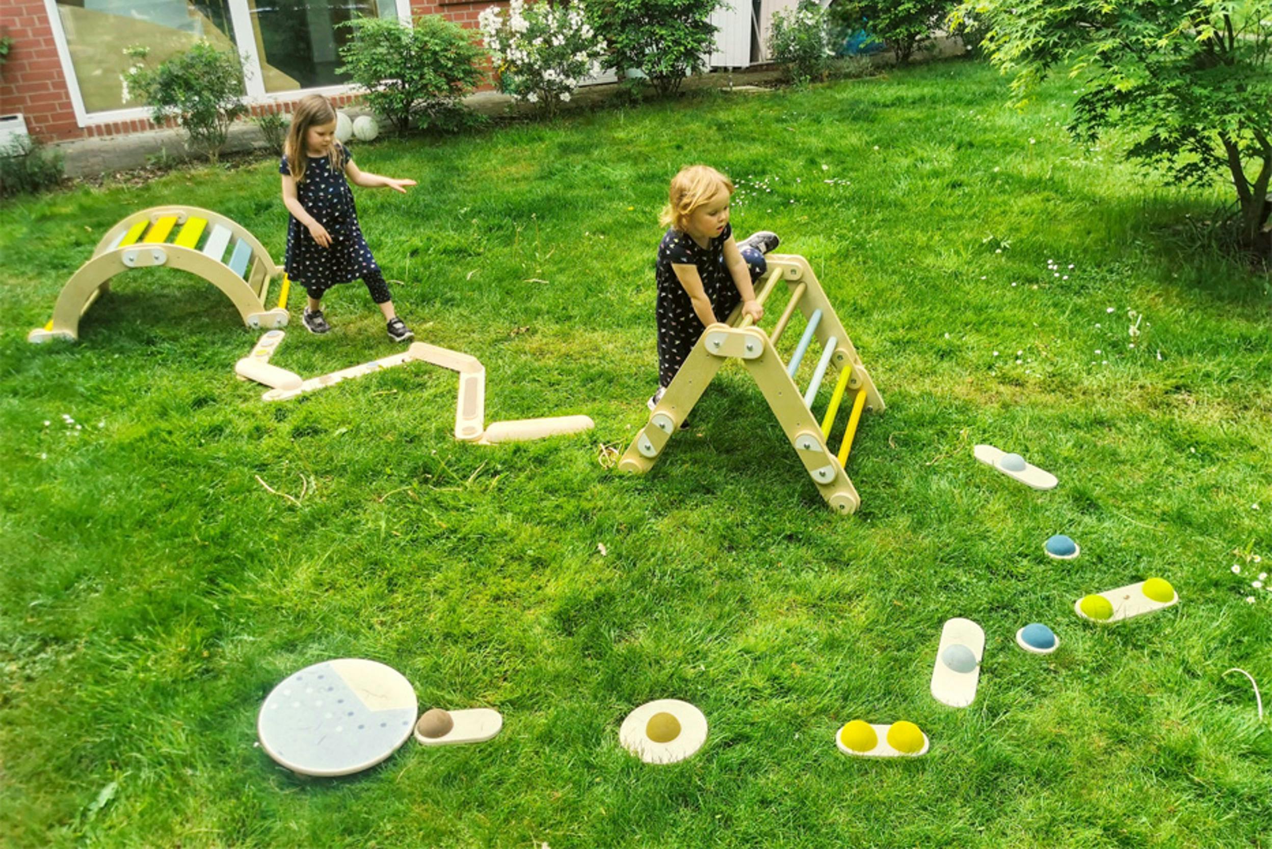 Zwei Kinder beim Bewältigen eines Hindernisparcours im Garten