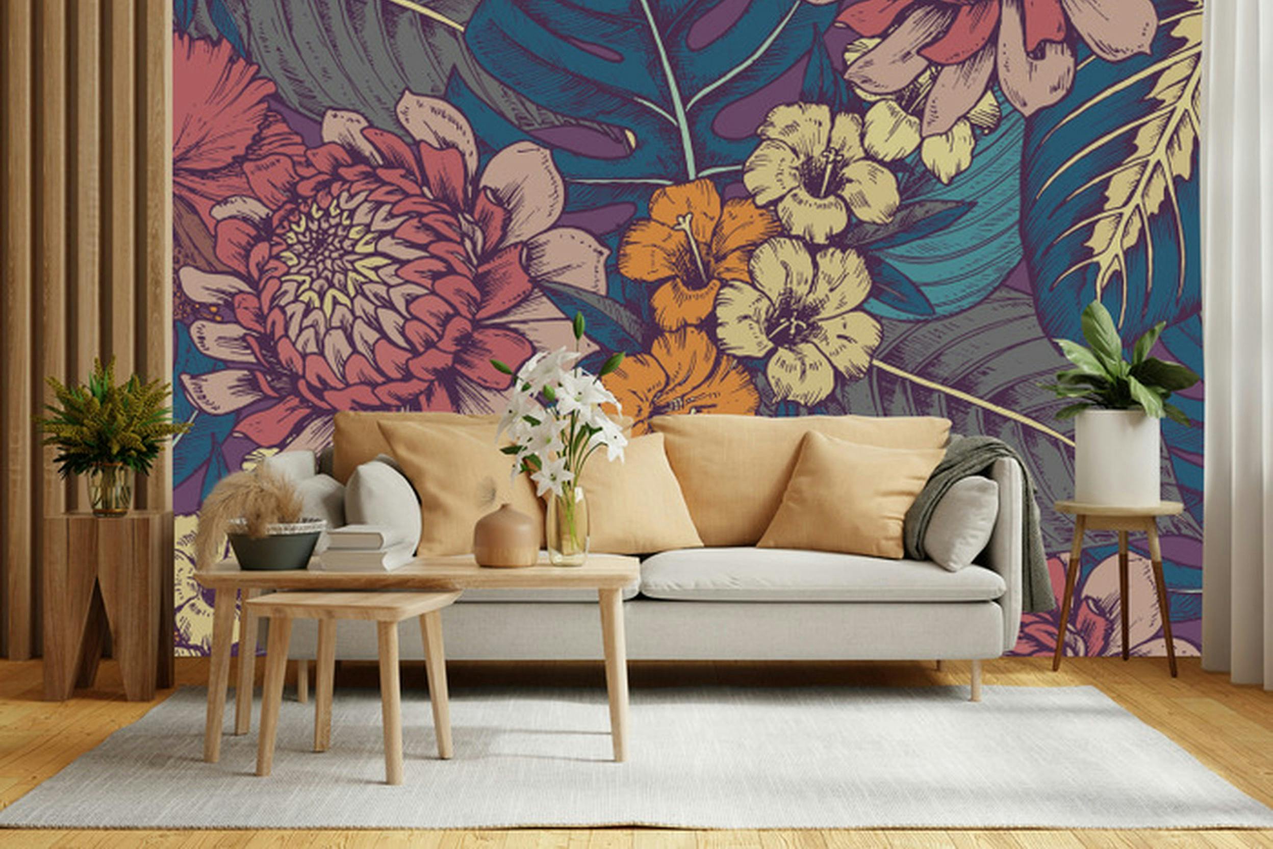 Florale Tapete hinter einer hellen Couch mit gelben Kissen und Satztischen aus Holz