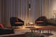 Wohnzimmer im Abendlicht mit Sesseln und schwarzer Pendelleuchte