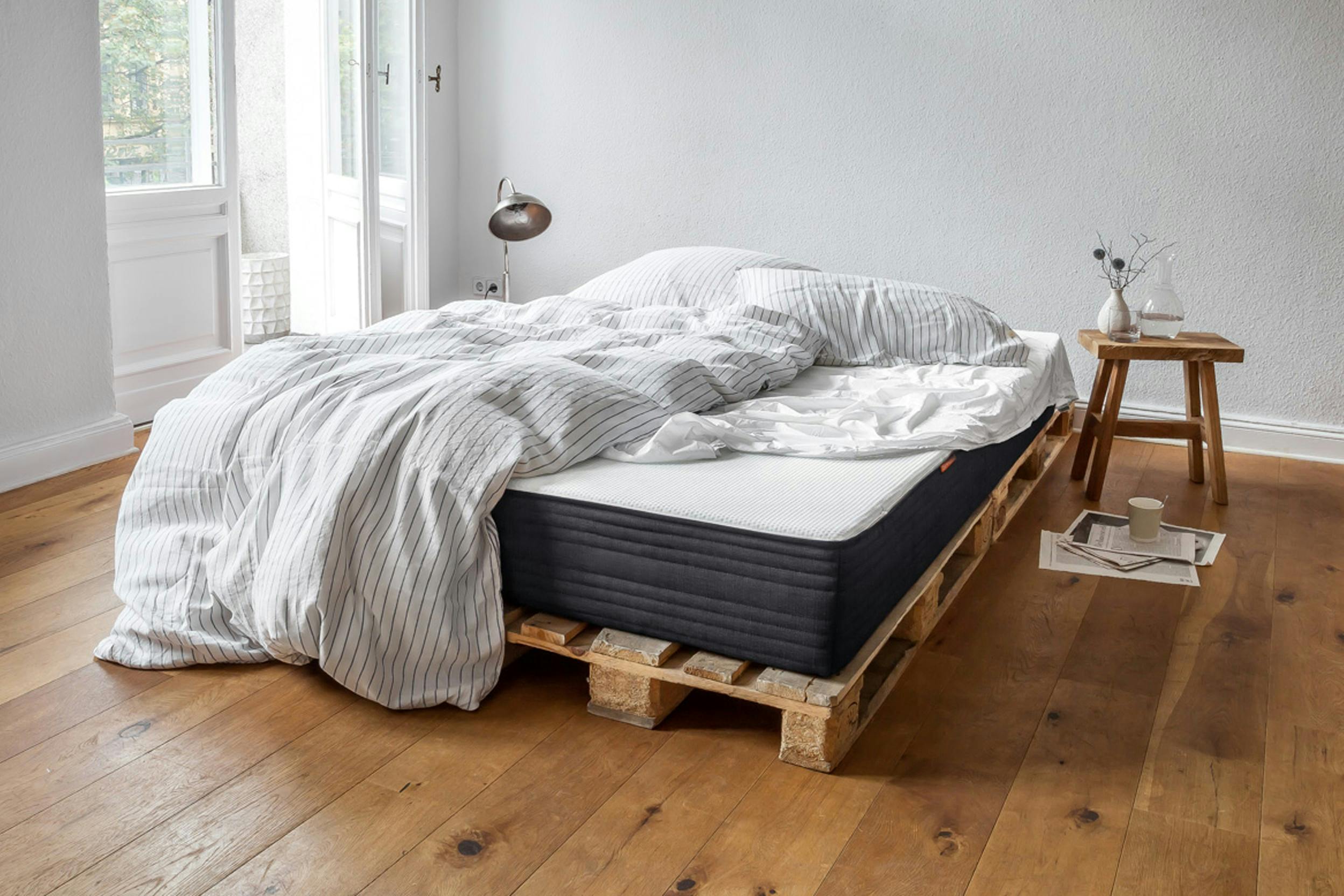 Puristisches Schlafzimmer mit Palettenbett und dicker Matratze