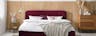 Slaapkamer in Scandi stijl met donkerrood gestoffeerd bed, houten meubels en glazen lamp