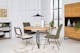Eetkamer met sledestoelen met Weens vlechtwerk en stoelen in chenille, plus een open kast in industriële stijl, een wit vloerkleed, een zwarte hanglamp, een muurschildering en decoratie.