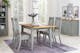 Salle à manger de style maison de campagne avec des meubles en bois gris clairs et un tapis couleur lilas