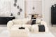 Salon noir et blanc avec canapé blanc Hudson de chez Studio Copenhagen sur un tapis fluffy blanc, avec meubles noirs posés devant des murs blancs et présentant des objets déco noirs et blancs.