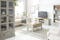 Salon qui revisite le style maison de campagne de façon moderne avec des meubles en bois gris clairs et des meubles capitonnés de couleur crème
