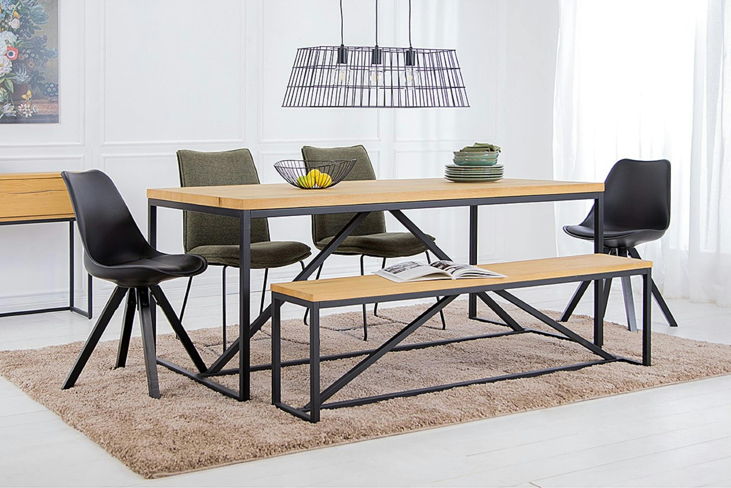 Esstisch mit Bank und vier Stühlen, darüber eine schwarze Pendelleuchte im Industrial-Design