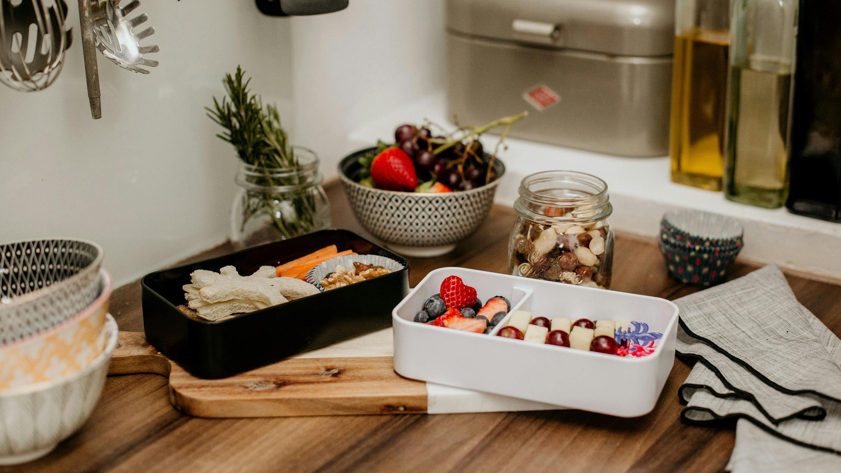 Lunchboxen in Weiß und Schwarz mit frischem Gemüse und Obst (Marke: Butlers).