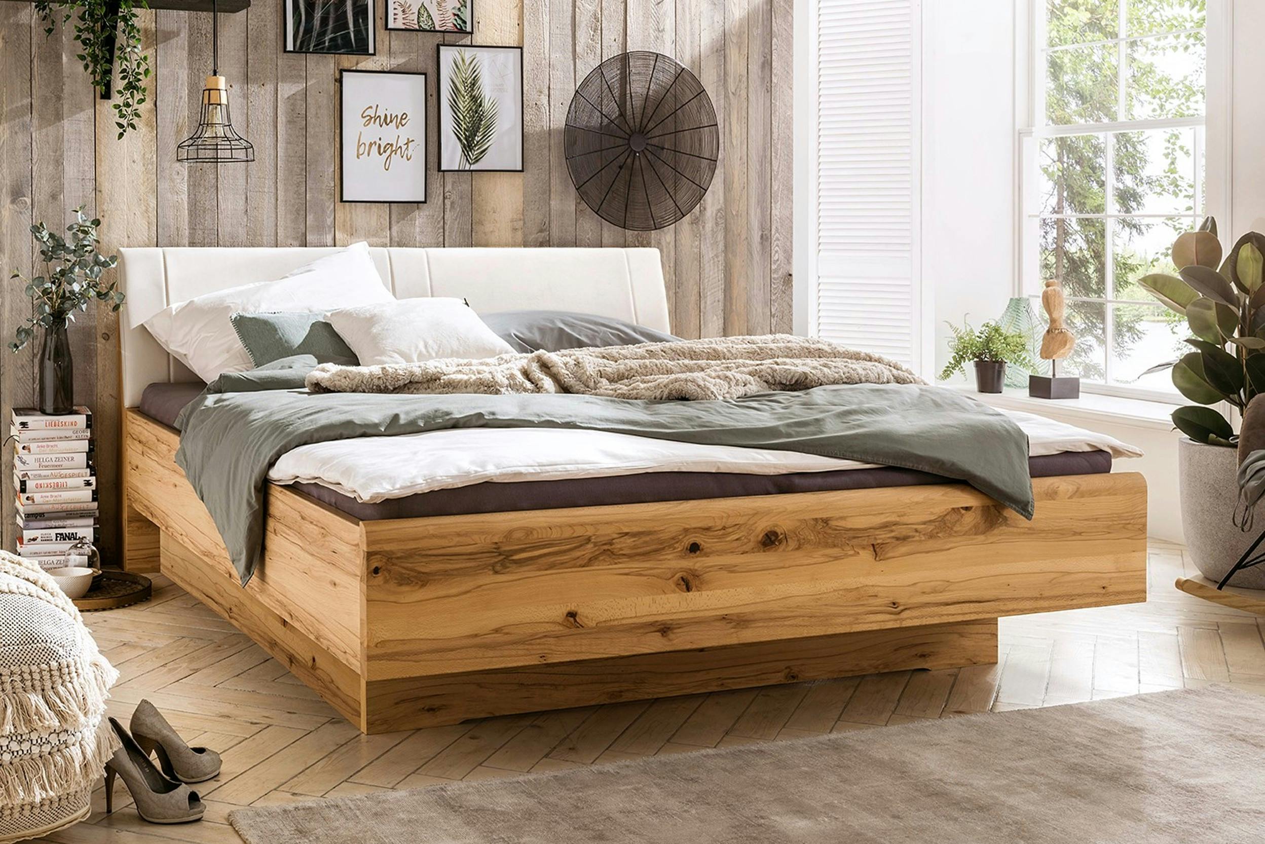 Geräumiges Holzbett vor einer Wand mit Holzpaneelen