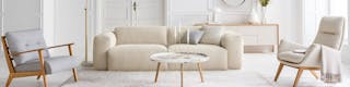 Photo d’un salon aménagé avec des éléments de couleur beige avec un canapé de la série Hudson de Studio Copenhagen, l’une des marques exclusives de home24, ainsi que d’autres meubles de la même marque.