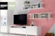 Weiße Stauraummöbel von hülsta im Wohnzimmer vor rosafarbener Wand