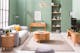 Canapé accueillant à la profondeur d'assise réglable et meubles en bois blond mis en valeur par un mur vert sauge