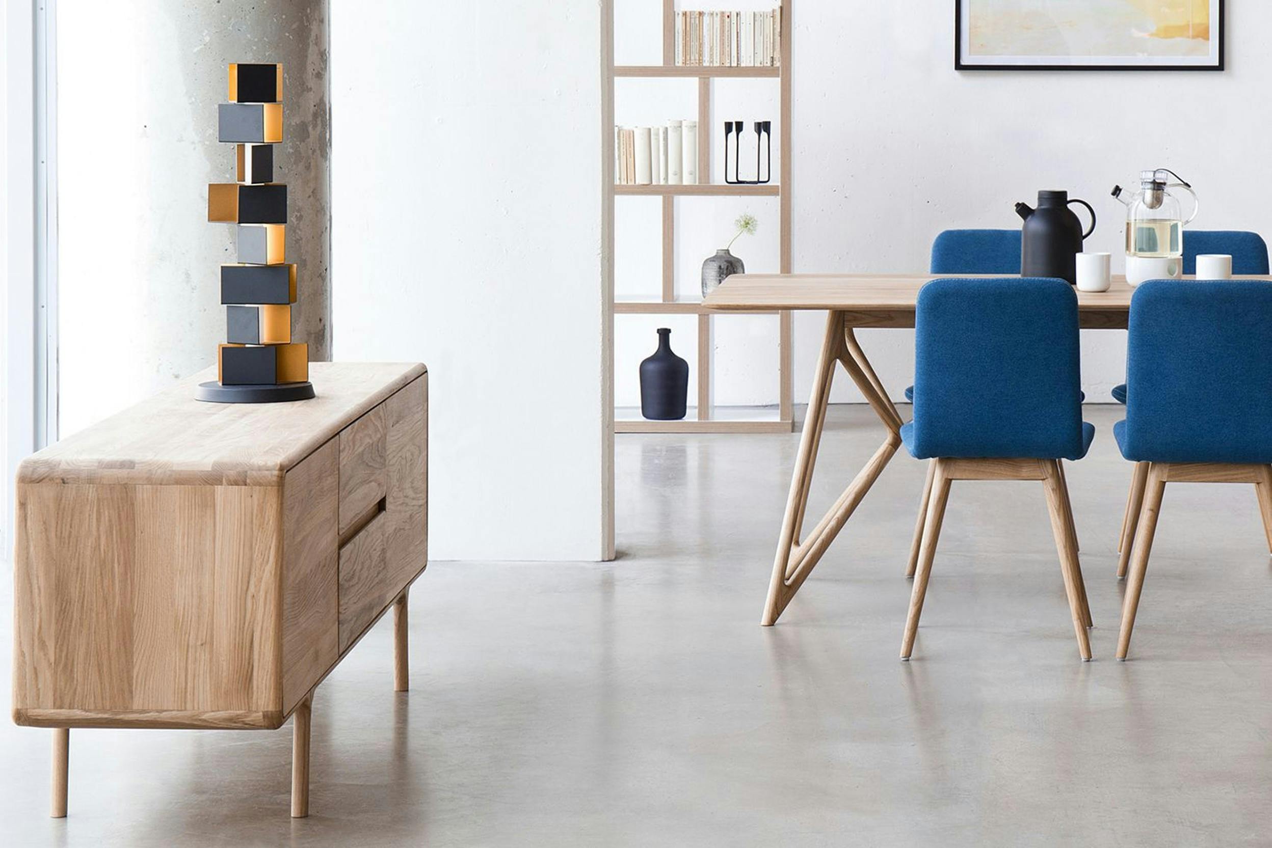 Esstisch, Sideboard und Regal in einheitlicher Holzfarbtönung sowie Esszimmerstühle in Blau