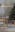 Salle à manger avec des meubles de Studio Copenhagen : une table en bois clair, des chaises cannées, un buffet blanc, un fauteuil gris et des suspensions en verre, un sapin de Noël décoré, une déco de table festive, de la vaisselle noire, des vases noirs et blancs avec de l'herbe de la pampa et autres objets décoratifs en noir et blanc.