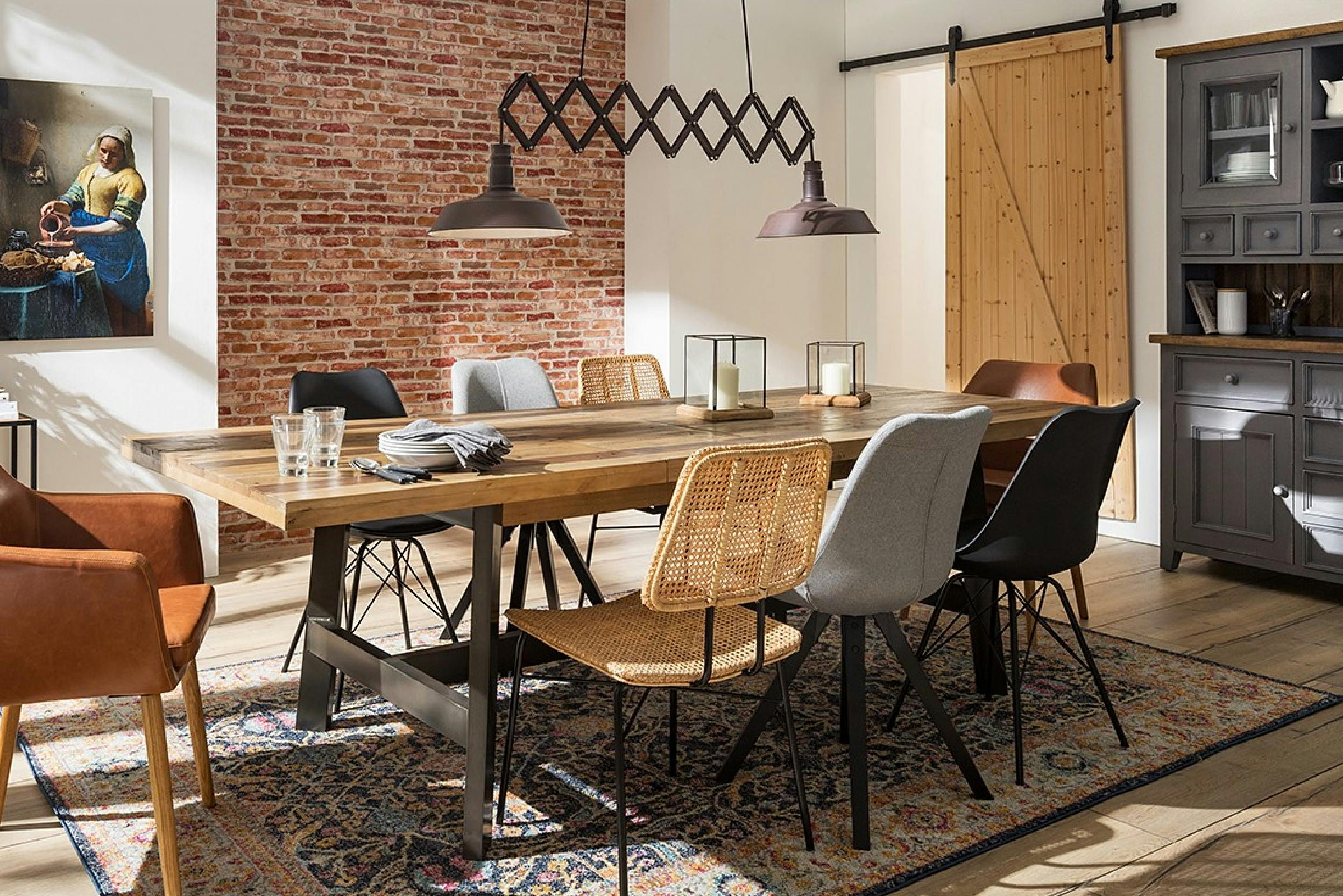 Langer Massivholztisch mit unterschiedliche Esszimmerstühle aus Leder, Kunststoff und Korbgeflecht