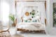 Schlafzimmer mit Himmelbett, weißer Bettwäsche, floralen Motiven und Rattansessel