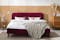 Rotes Polsterbett vor Holzfront im kuscheligen Skandi-Schlafzimmer