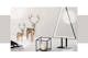 Minimalistische kerstdecoratie tegen een lichte achtergrond: zwart-witte plaid, gouden beeldjes van herten, kleine zwarte lantaarn, LED-kerstboom in een eenvoudige driehoekige vorm, evenals drie brandende kaarsen.