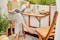 Coin de balcon avec table en bois pliante accrochée au mur, deux chaises assorties, et une plante