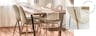 Chaises en velours couleur crème avec pieds dorés, lampadaire doré dans une salle à manger qui marie hygge et glamour