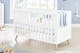 Chambre de bébé lumineuse dans les tons blanc et bleu clair, avec un berceau en bois massif blanc