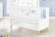 Chambre de bébé lumineuse dans les tons blanc et bleu clair, avec un berceau en bois massif blanc
