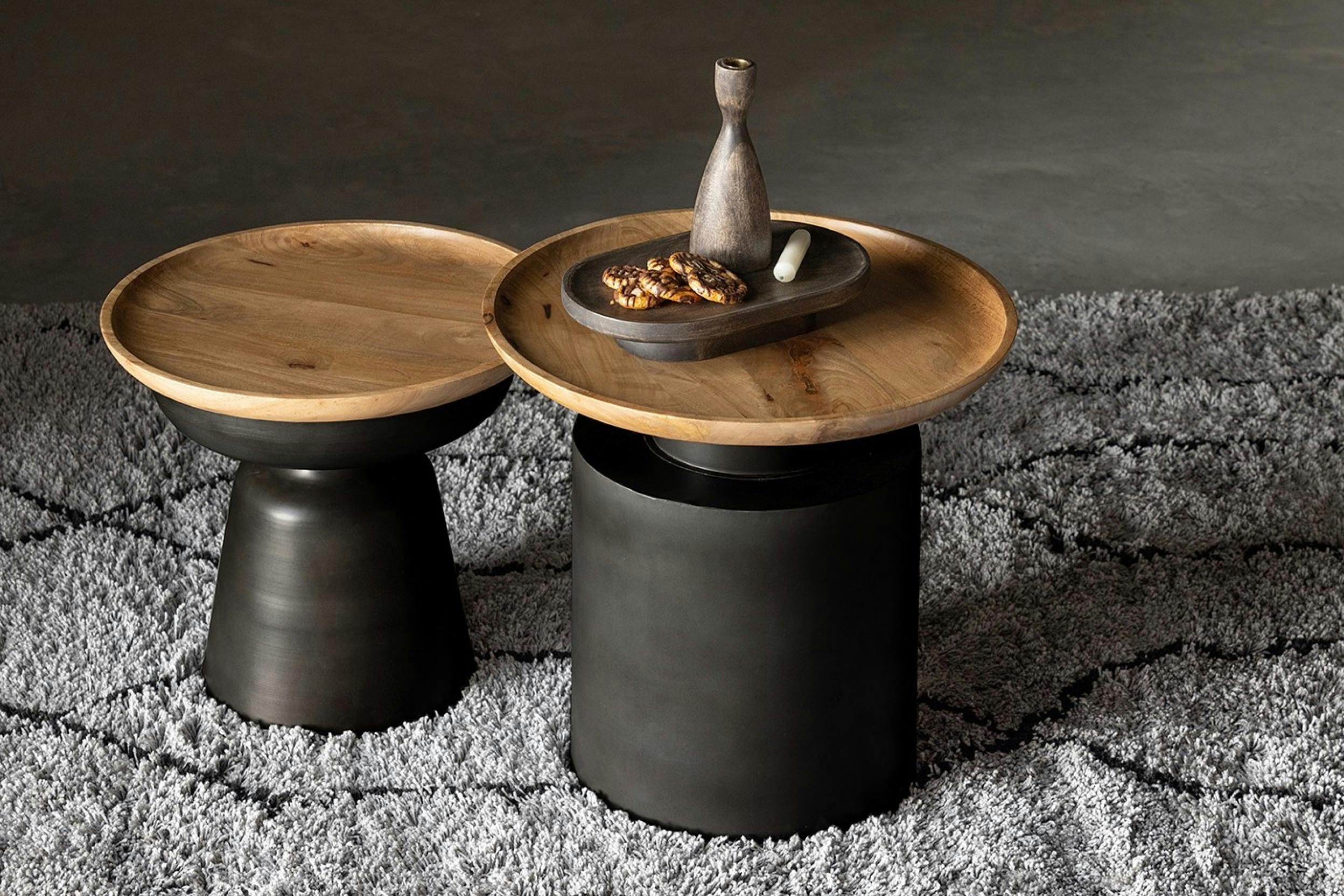 Zwei runde schwarze Beistelltische in verschiedenen Größen, jeweils mit einer Holzplatte