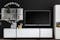Collage aus zwei Wohnzimmer-Settings: moderne TV-Möbel, Wandboard und Highboard in Weiß vor schwarzer Rückwand sowie ein TV-Lowboard in schwarzer Marmoroptik mit Wandbehang und Teppich in Beige und Schwarz