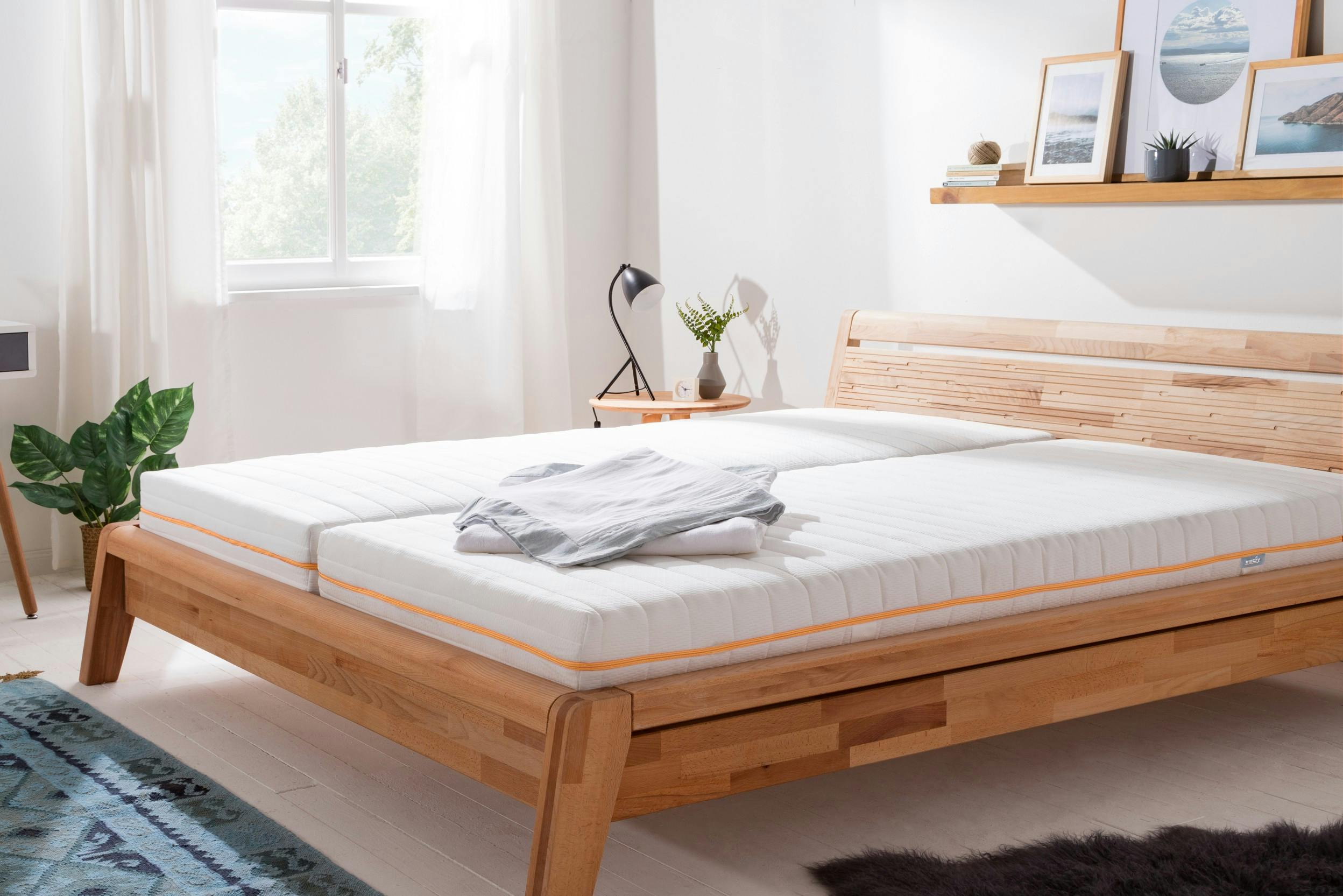 Helles Schlafzimmer mit einem Doppelbett aus Holz mit zwei getrennten Matratzen