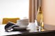 Schwarzer Esstisch mit gelber Glasvase und Geschirr vor senfgelbem Polsterstuhl