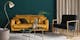 Wohnzimmer mit Samtsofa in Honigfarben, Sessel mit Messingrahmen und Couchtisch im Marmor-Look
