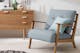 Fauteuil capitonné bleu et buffet au design scandinave d'inspiration rétro