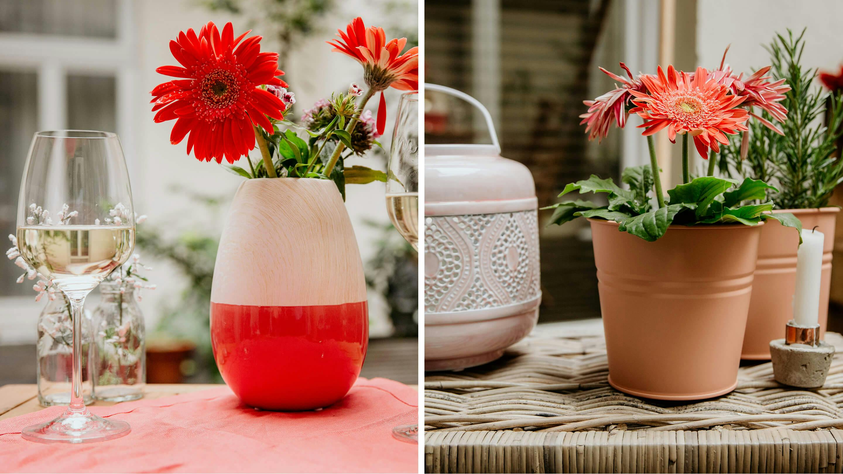 Weissweinglas und Vase in Rot-Beige (links), 2 Blumen im Topf, Kerzenhalter mit weißer Kerze, rosa Laterne (Marke: Butlers).