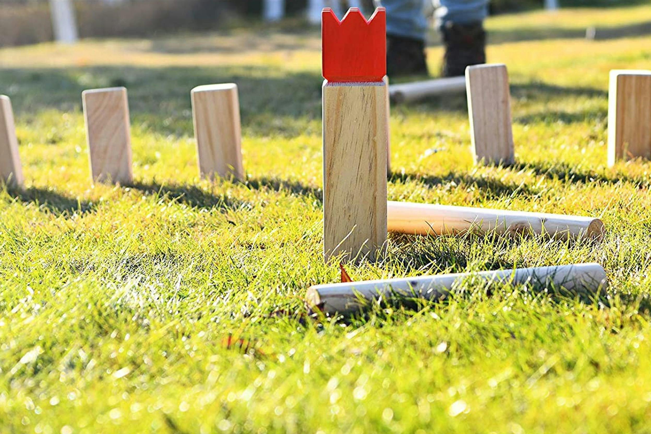 Detailaufnahme eines klassischen Kubb-Spiels aus Holz auf grünem Gras