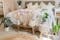 Schlafzimmer im Boho-Stil mit handgewebtem Juteteppich, Grünpflanzen und natürlicher Deko