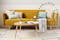 Canapé clic-clac jaune moutarde avec table basse en bois vus de face et vue plogeante sur le même canapé déplié en lit