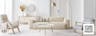 Beigefarbenes Einzelsofa Hudson von Studio Copenhagen mit Bouclé-Bezug auf einem beigen Teppich sowie zwei Sesseln im Skandi-Stil, einem runden Couchtisch mit ausgestellten Holzbeinen und goldenen Accessoires