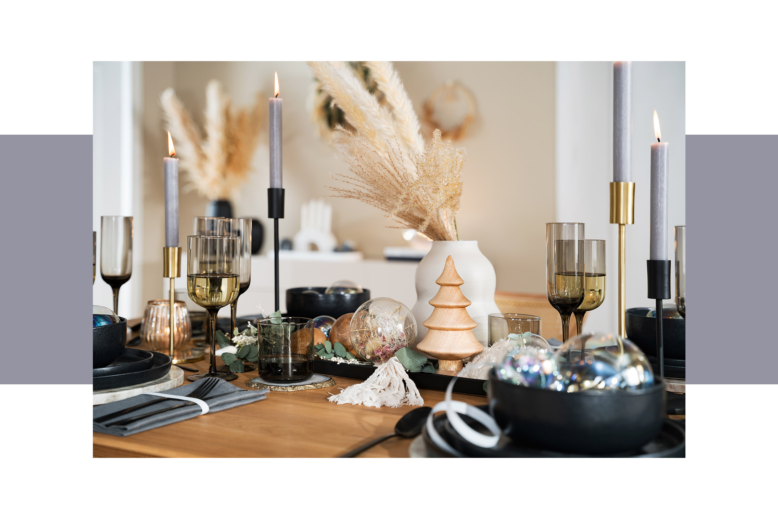Weihnachtliche Tischdeko, schwarze Geschirrsets und Trinkgläser, schwarze und weiße Vasen mit Pampasgras sowie weitere Deko in Schwarz und Weiß.