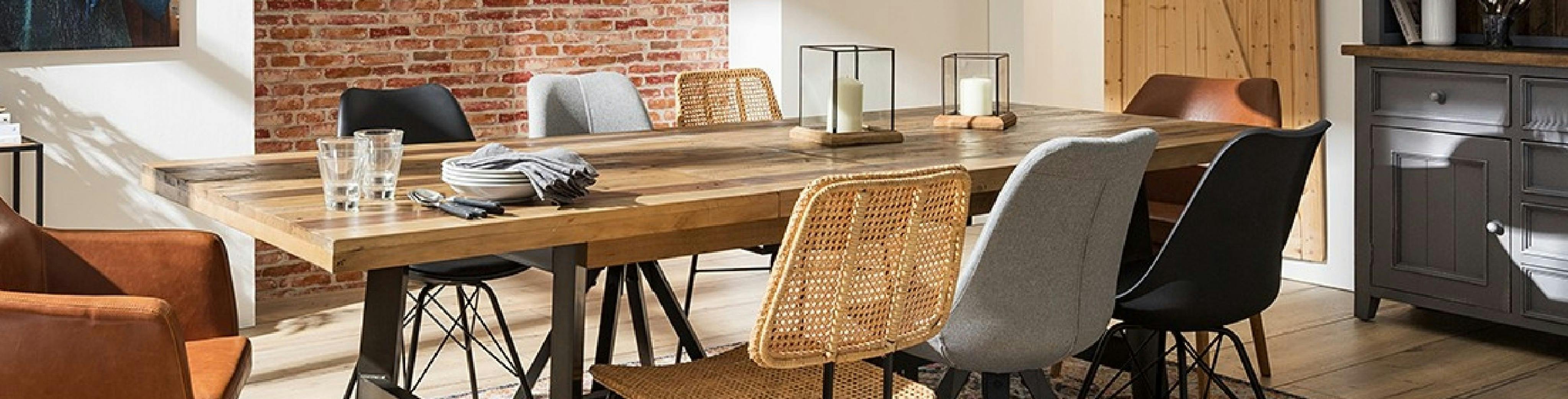 Langer Massivholztisch mit unterschiedliche Esszimmerstühle aus Leder, Kunststoff und Flechtgewebe